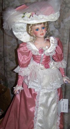 a doll wearing a pink dress and white hat