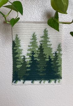 a crocheted wall hanging with trees on it