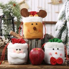 three christmas ornaments sitting on top of a wooden table next to pine cones and an apple