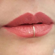 a woman's lips with a ring on her lip and the bottom part of her lip