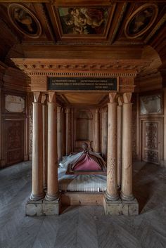 a bed sitting in the middle of a room between two pillars