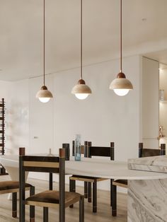 a dining room with marble table and four pendant lights hanging from it's ceiling