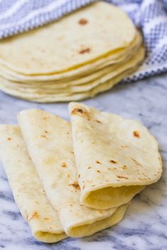 several tortillas stacked on top of each other next to a blue and white towel