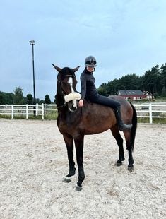 a woman riding on the back of a brown horse