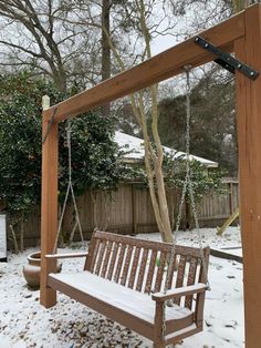 a wooden swing and bench in the snow