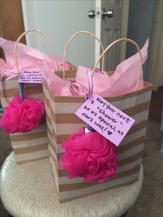 two brown and white bags with pink pom poms on them sitting on a chair