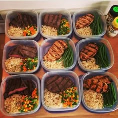 six plastic containers filled with meat and rice on a wooden table next to a bottle of ketchup