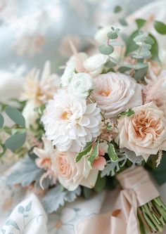 a bridal bouquet with pink and white flowers on a bed sheet in the sunlight