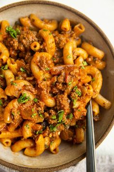 a bowl filled with pasta and meat on top of a table