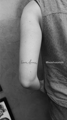 a woman's arm with the word love written in cursive writing on it