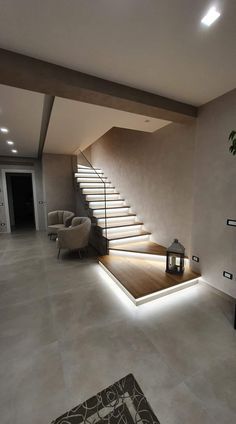 a living room filled with furniture next to a stair case and light on the wall