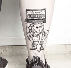 a person with a tattoo on their leg has an old school style cassette tape attached to it