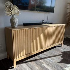 a large television mounted to the side of a wooden cabinet in front of a wall