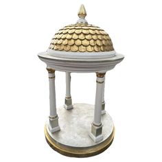 a small white and gold dome with columns