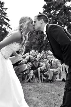 a bride and groom kissing in front of an audience