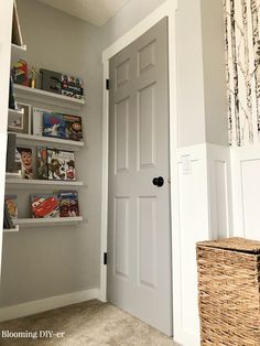 a white door with bookshelves and baskets in front of it on the wall