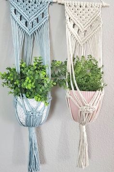 two macrame wall hangings with plants in them