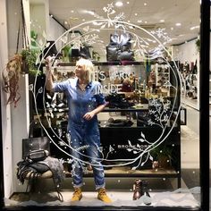 a woman standing in front of a store window