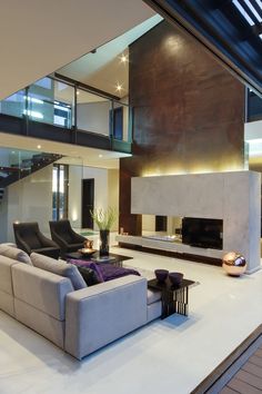 a modern living room with large couches and a fire place in the center area