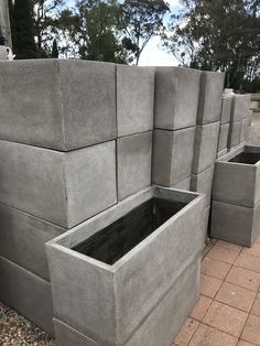 several cement planters are lined up on the ground