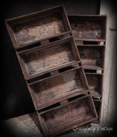 two old wooden boxes are stacked on top of each other in an empty room with dark walls