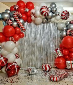 red and white balloons, candy canes, and streamers are arranged in the shape of a heart