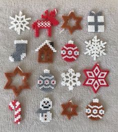 cross stitch christmas ornament patterns on a white towel with red and black snowflakes