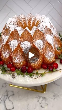 a bundt cake with cherries and powdered sugar is on a white plate