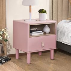 a pink nightstand with a lamp on top of it