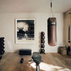 a boxing bag hanging from the ceiling in a room with hard wood floors and white walls