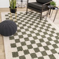 a living room area with a rug, chair and potted plant