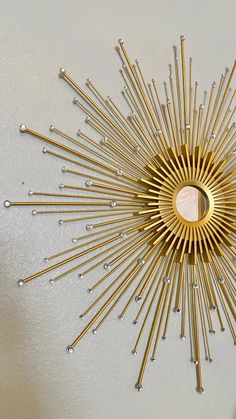 a gold sunburst is hanging on the wall