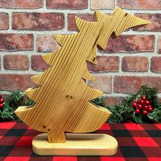 a wooden christmas tree sitting on top of a red and black checkered table cloth