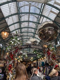 the inside of a building with lots of christmas decorations and lights hanging from it's ceiling