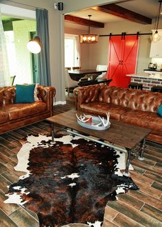 a living room with two couches and a cowhide rug