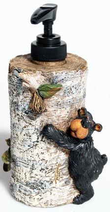 a soap dispenser made out of wood with a bear and bird on it