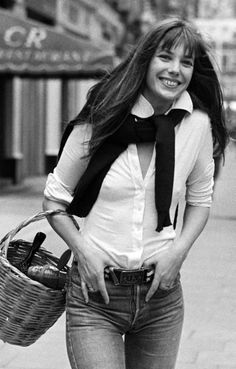 black and white photograph of a woman with long hair holding a basket in her hand