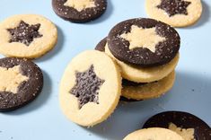 several cookies with chocolate and white frosting are arranged on a blue surface, including one star