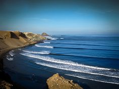 an ocean view with waves coming in and out of the water, on a sunny day