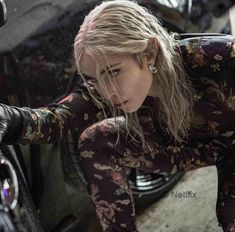 a woman leaning on the side of a motorcycle