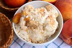 a bowl filled with ice cream next to some peaches