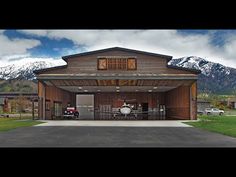 an image of a large garage with mountains in the backgrouds and cars parked outside