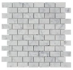 a white marble brick wall with grey and white tiles