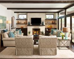 a living room filled with furniture and a flat screen tv mounted on the wall above a fireplace