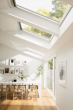 a dining room filled with lots of furniture under a skylight over a wooden floor