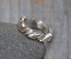 a silver ring sitting on top of a rock