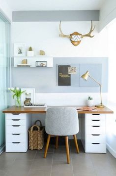 a desk with a chair, lamp and pictures on the wall