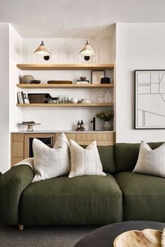 a living room filled with lots of furniture and shelves on the wall above it is a green couch