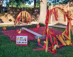 some decorations are laying on the grass in front of a tree and fenced area