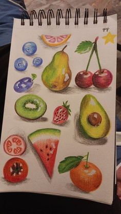 a drawing of different fruits and vegetables on a sheet of paper with markers in front of it